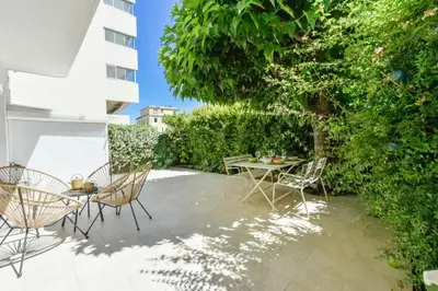 a patio with a table and chairs and a tree at Résidence Rez-de-jardin, Plages à Pied Et Garage - Rez-de-jardin, plages à pied et garage MAE-2723 in Cannes
