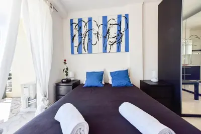 a bedroom with a large bed with blue pillows at Résidence Cosy 3p En Dernier étage, Terrasse Et Vue Mer - Cosy 3P en dernier étage, terrasse et vue mer MAE-2733 in Cannes