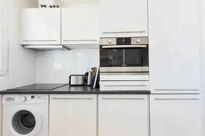a white kitchen with a microwave and a washer and dryer at Résidence Cosy 3p En Dernier étage, Terrasse Et Vue Mer - Cosy 3P en dernier étage, terrasse et vue mer MAE-2733 in Cannes