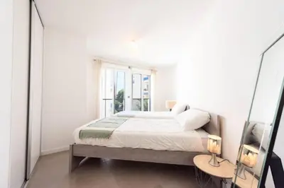 a white bedroom with a bed and a window at Résidence 3p Piscine, Parking Et Plages à 100m - 3P piscine, parking et plages à 100m MAE-2763 in Cannes