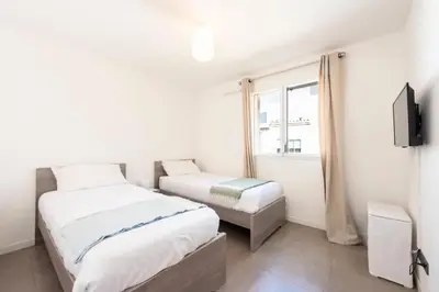 a bedroom with two beds and a tv and a window at Résidence 3p Piscine, Parking Et Plages à 100m - 3P piscine, parking et plages à 100m MAE-2763 in Cannes