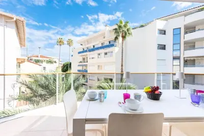 a white dining room with a table and chairs on a balcony at Résidence 3p Piscine, Parking Et Plages à 100m - 3P piscine, parking et plages à 100m MAE-2763 in Cannes