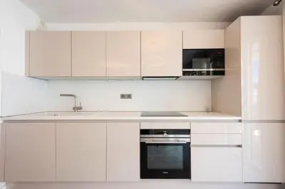 a white kitchen with white cabinets and a sink at Résidence 3p Piscine, Parking Et Plages à 100m - 3P piscine, parking et plages à 100m MAE-2763 in Cannes