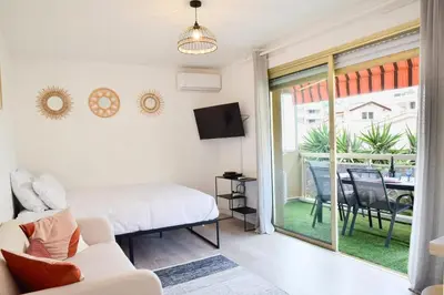 a bedroom with a bed and a sliding glass door at Résidence Palm Beach Studio Avec Terrasse A 150m Des Plages - Palm Beach studio avec terrasse a 150m des plages MAE-2773 in Cannes