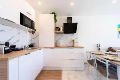a kitchen with white cabinets and a table at Résidence 2p Rénové Proche Croisette - 2P Rénové proche Croisette MAE-2783 in Cannes