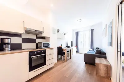 a kitchen with white cabinets and a living room at Résidence Cannes 2p Carré D’or - Cannes 2p Carré d’Or MAE-2793 in Cannes