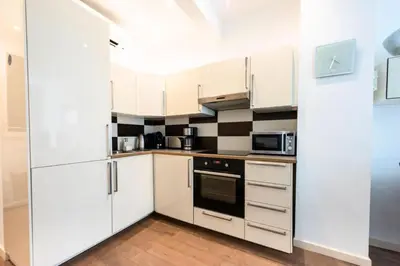 a white kitchen with white cabinets and appliances at Résidence Cannes 2p Carré D’or - Cannes 2p Carré d’Or MAE-2793 in Cannes