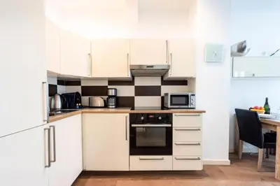 a small kitchen with white cabinets and a table at Résidence Cannes 2p Carré D’or - Cannes 2p Carré d’Or MAE-2793 in Cannes