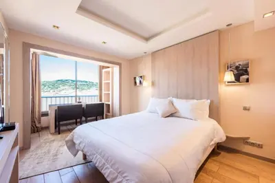 a bedroom with a large bed and a dining room at Résidence 2 Pièces Croisette, Face Palais Des Congrès - 2 pièces Croisette, Face Palais des Congrès MAE-2833 in Cannes