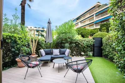 a patio with a couch and chairs and an umbrella at Résidence Rare ! 3p Piscines, Plages Et Parking - RARE ! 3P piscines, plages et parking MAE-2853 in Cannes