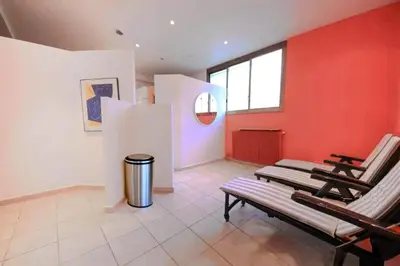 a room with two chairs and a red wall at Résidence Rare ! 3p Piscines, Plages Et Parking - RARE ! 3P piscines, plages et parking MAE-2853 in Cannes