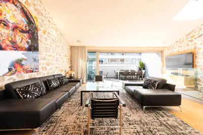 a living room with a black couch and a table at Résidence Duplex 145m² Terrasse Et Ascenseur Privé - DUPLEX 145m² Terrasse et Ascenseur Privé MAE-2873 in Cannes