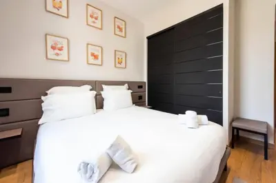a bedroom with a large white bed with a black headboard at Résidence Duplex 145m² Terrasse Et Ascenseur Privé - DUPLEX 145m² Terrasse et Ascenseur Privé MAE-2873 in Cannes