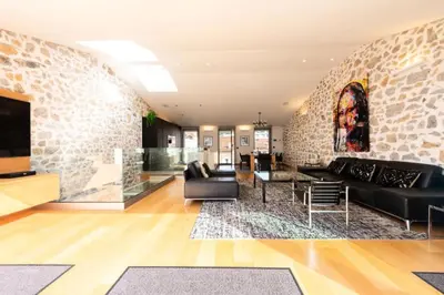 a living room with a stone wall at Résidence Duplex 145m² Terrasse Et Ascenseur Privé - DUPLEX 145m² Terrasse et Ascenseur Privé MAE-2873 in Cannes