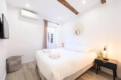 a white bedroom with a large bed and a mirror at Résidence 3p Centre Cannes Suquet - 3P Centre Cannes Suquet MAE-2903 in Cannes