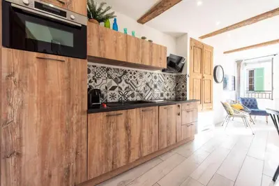 a kitchen with wooden cabinets and a flat screen tv at Résidence 3p Centre Cannes Suquet - 3P Centre Cannes Suquet MAE-2903 in Cannes