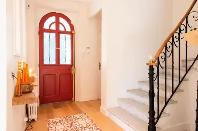 a red door in a white hallway with stairs at Résidence Villa 180m² 5p Cannes Piscine Garage - Villa 180m² 5P Cannes Piscine Garage MAE-2963 in Cannes