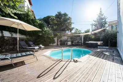 a swimming pool on a wooden deck with an umbrella at Résidence Villa 180m² 5p Cannes Piscine Garage - Villa 180m² 5P Cannes Piscine Garage MAE-2963 in Cannes