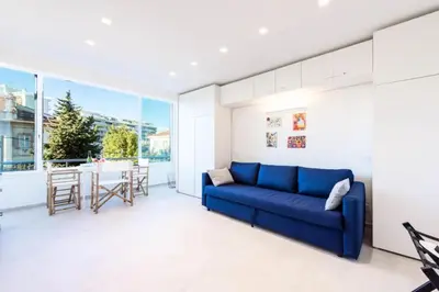 a living room with a blue couch and a table at Résidence 2p Au Calme Proche Centre Cannes - 2P au Calme proche Centre Cannes MAE-2983 in Cannes