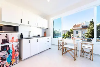a kitchen with white cabinets and a large window at Résidence 2p Au Calme Proche Centre Cannes - 2P au Calme proche Centre Cannes MAE-2983 in Cannes