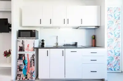 a kitchen with white cabinets and a refrigerator at Résidence 2p Au Calme Proche Centre Cannes - 2P au Calme proche Centre Cannes MAE-2983 in Cannes