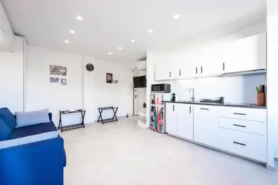 a kitchen with white cabinets and a blue couch at Résidence 2p Au Calme Proche Centre Cannes - 2P au Calme proche Centre Cannes MAE-2983 in Cannes