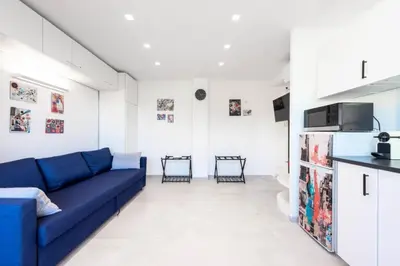 a living room with a blue couch and a kitchen at Résidence 2p Au Calme Proche Centre Cannes - 2P au Calme proche Centre Cannes MAE-2983 in Cannes