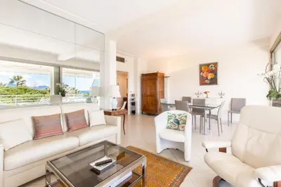 a living room with a couch and a table at Résidence Vue Mer 95m2 Grande Terrasse Cannes Croisette. - Vue mer 95m2 Grande Terrasse Cannes Croisette. MAE-3003 in Cannes