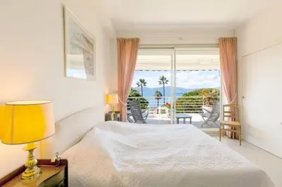 a bedroom with a bed and a view of the ocean at Résidence Vue Mer 95m2 Grande Terrasse Cannes Croisette. - Vue mer 95m2 Grande Terrasse Cannes Croisette. MAE-3003 in Cannes