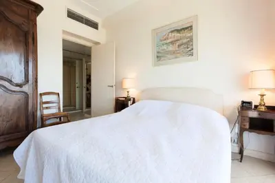 a bedroom with a white bed and a desk at Résidence Vue Mer 95m2 Grande Terrasse Cannes Croisette. - Vue mer 95m2 Grande Terrasse Cannes Croisette. MAE-3003 in Cannes