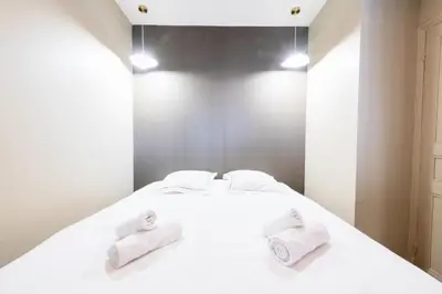 a bedroom with a white bed with towels on it at Résidence 2p Rénové Cœur De Cannes - 2P Rénové Cœur de Cannes MAE-3013 in Cannes