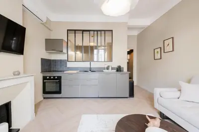 a kitchen with white cabinets and a living room at Résidence 2p Rénové Cœur De Cannes - 2P Rénové Cœur de Cannes MAE-3013 in Cannes