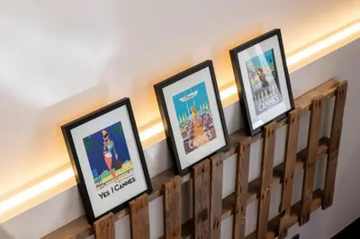 a row of framed pictures on a wooden rail at Résidence 2p Duplex 75m² Avec Piscine - 2P Duplex 75m² avec Piscine MAE-3023 in Cannes