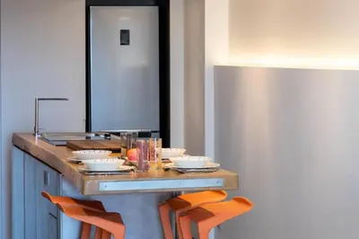 a kitchen with a counter with chairs around it at Résidence 2p Duplex 75m² Avec Piscine - 2P Duplex 75m² avec Piscine MAE-3023 in Cannes