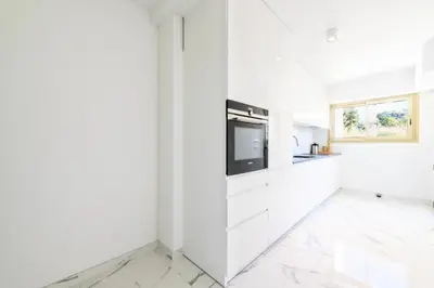 a white kitchen with white cabinets and a tv at Résidence Spacieux 3p En Résidence Avec Piscine - Spacieux 3P en Résidence avec Piscine MAE-3033 in Cannes