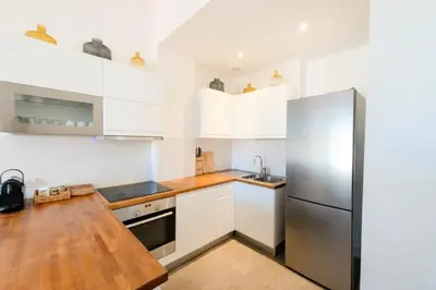 a kitchen with white cabinets and a stainless steel refrigerator at Résidence 3p Avec Balcons, 3min Du Palais Des Congrès - 3P avec Balcons, 3min du Palais des congrès MAE-3053 in Cannes