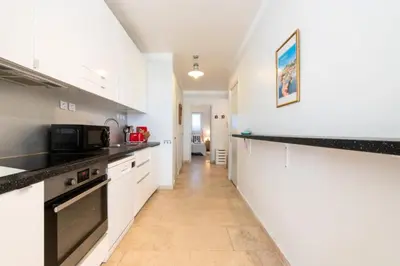 a kitchen with white cabinets and black counter tops at Résidence Rez-de-jardin Croisette Vue Mer Avec Garage - Rez-de-jardin Croisette vue mer avec garage MAE-3083 in Cannes