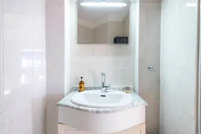 a white bathroom with a sink and a mirror at Résidence Rez-de-jardin Croisette Vue Mer Avec Garage - Rez-de-jardin Croisette vue mer avec garage MAE-3083 in Cannes