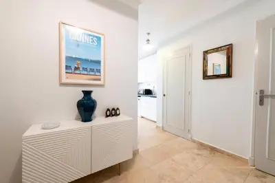a hallway with white walls and a vase on a dresser at Résidence Rez-de-jardin Croisette Vue Mer Avec Garage - Rez-de-jardin Croisette vue mer avec garage MAE-3083 in Cannes