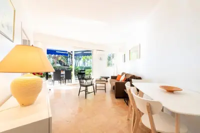 a living room with a table and a couch at Résidence Rez-de-jardin Croisette Vue Mer Avec Garage - Rez-de-jardin Croisette vue mer avec garage MAE-3083 in Cannes