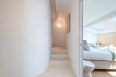 a bedroom with white walls and a bed and a staircase at Résidence 4p Duplex Mansardé, Cœur De Cannes - 4P Duplex Mansardé, Cœur de Cannes MAE-3103 in Cannes
