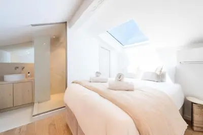 a white bedroom with a large bed and a bathroom at Résidence 4p Duplex Mansardé, Cœur De Cannes - 4P Duplex Mansardé, Cœur de Cannes MAE-3103 in Cannes