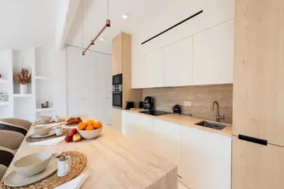 a kitchen with white cabinets and a table with fruit on it at Résidence 4p Duplex Mansardé, Cœur De Cannes - 4P Duplex Mansardé, Cœur de Cannes MAE-3103 in Cannes