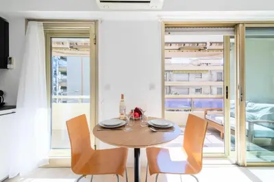 a dining room with a wooden table and chairs at Résidence Studio Terrasse 2 Min De La Croisette - Studio Terrasse 2 min de la Croisette MAE-3113 in Cannes