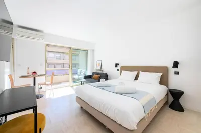 a bedroom with a large bed and a living room at Résidence Studio Terrasse 2 Min De La Croisette - Studio Terrasse 2 min de la Croisette MAE-3113 in Cannes