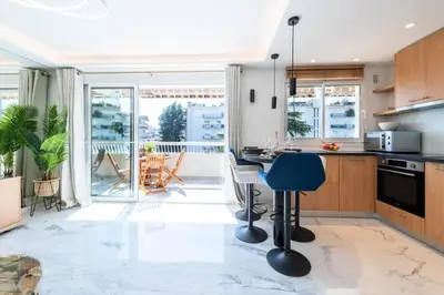 a kitchen with a table and a blue chair at Résidence Grand 2p Rénové Terrasse Cœur De Cannes - Grand 2P rénové Terrasse Cœur de Cannes MAE-3143 in Cannes