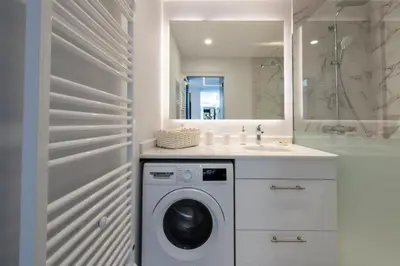 a bathroom with a washing machine and a mirror at Résidence Grand 2p Rénové Terrasse Cœur De Cannes - Grand 2P rénové Terrasse Cœur de Cannes MAE-3143 in Cannes