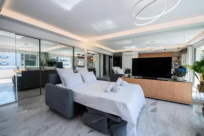 a bedroom with a large white bed and a television at Résidence Grand 2p Rénové Terrasse Cœur De Cannes - Grand 2P rénové Terrasse Cœur de Cannes MAE-3143 in Cannes