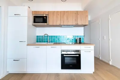 a white kitchen with white cabinets and a stove at Résidence Cannes – Suquet Vue Mer & Accès Plage - Cannes – Suquet Vue Mer & Accès Plage MAE-3163 in Cannes