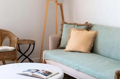 a living room with a couch with a pillow and a table at Résidence Cannes – Suquet Vue Mer & Accès Plage - Cannes – Suquet Vue Mer & Accès Plage MAE-3163 in Cannes
